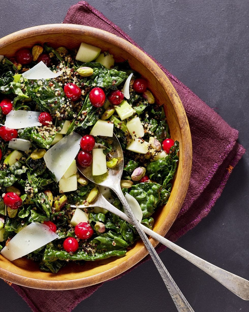 kale salad with pickled cranberries and crispy quinoa thanksgiving salad in a wooden bowl