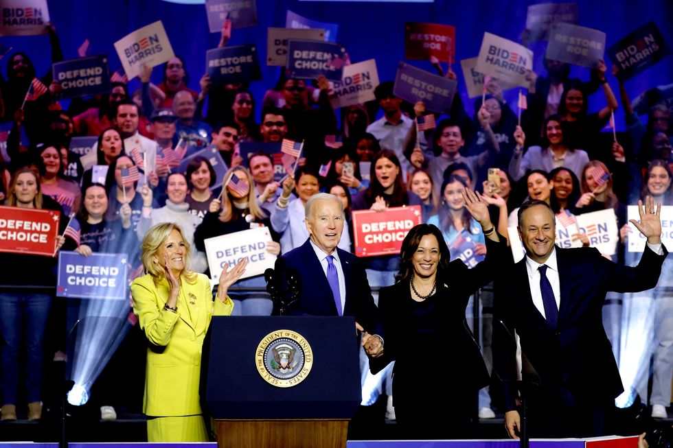 first lady jill biden us president joe biden us vice president kamala harris and second gentleman douglas emhoff join hands as they depart a reproductive freedom campaign rally