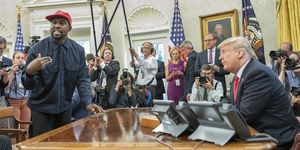 surrounded by members of the press and others, american rapper and producer kanye west stands as he talks with real estate developer and us president donald trump in the white house's oval office, washington dc, october 11, 2018 west wears a red baseball cap that reads 'make america great again,' trump's campaign slogan photo by ron sachsconsolidated news picturesgetty images