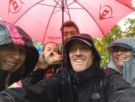 group of runners shelter under umbrella