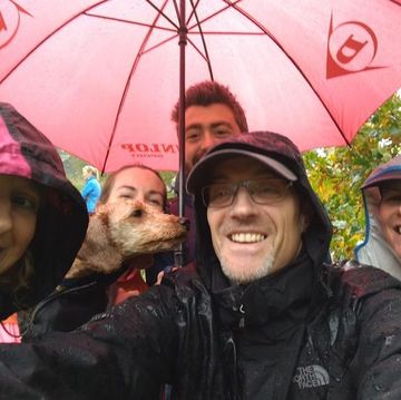 group of runners shelter under umbrella