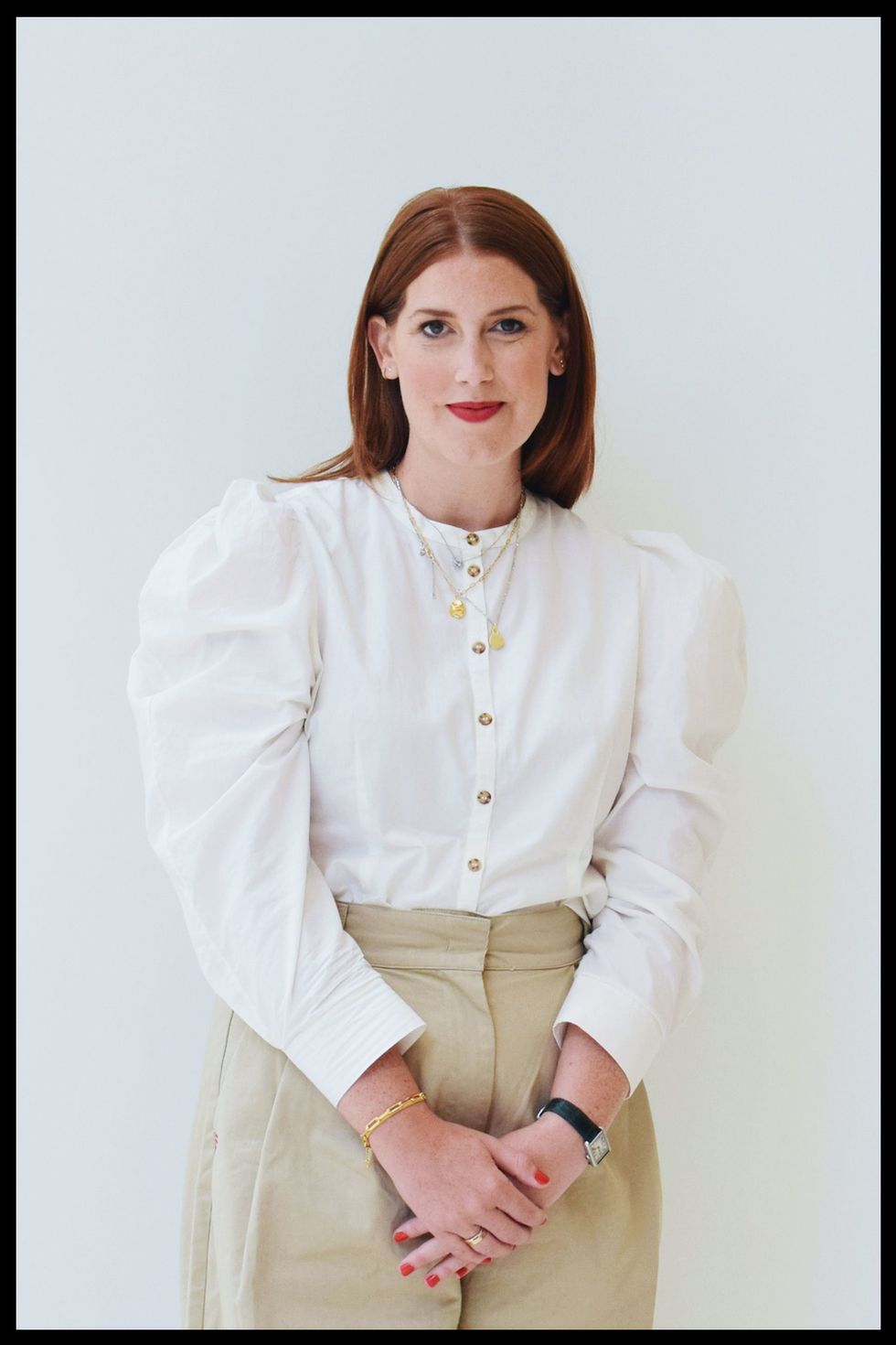 katie bellman from nordstrom stands in front of a white wall wearing a blouse and khakis to illustrate her style resolution for 2022