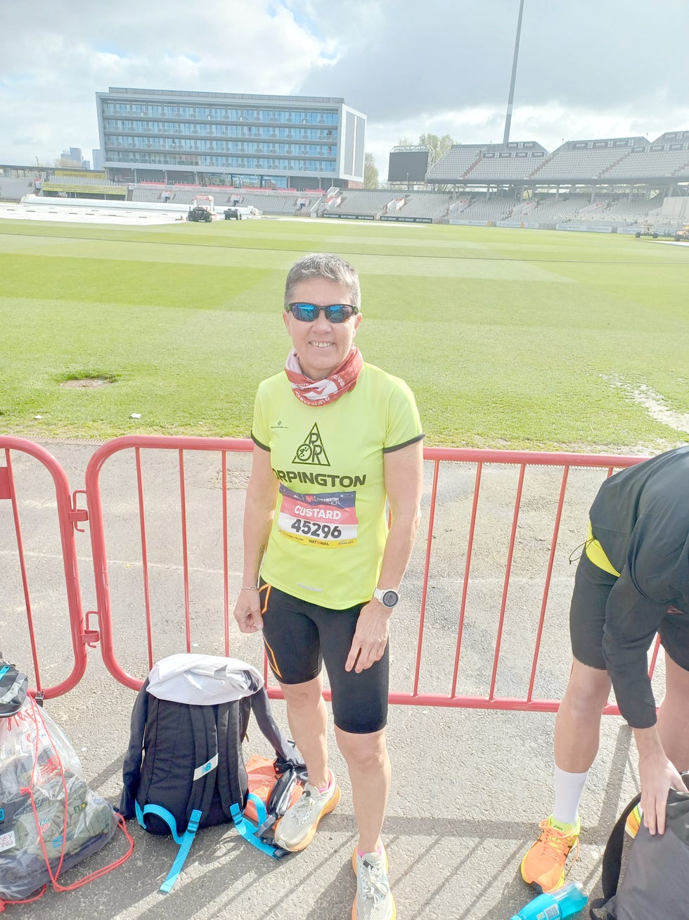 a runner in a bright yellow shirt preparing for a race at a sports venue