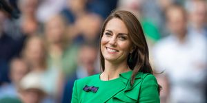 kate middleton smiling at the camera wearing a green dress