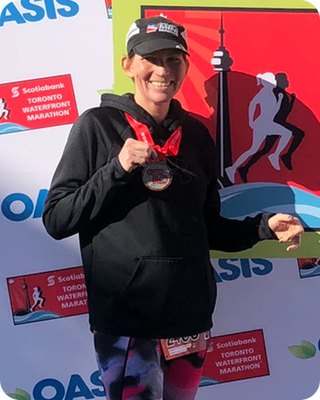 runner standing in front of marathon sign