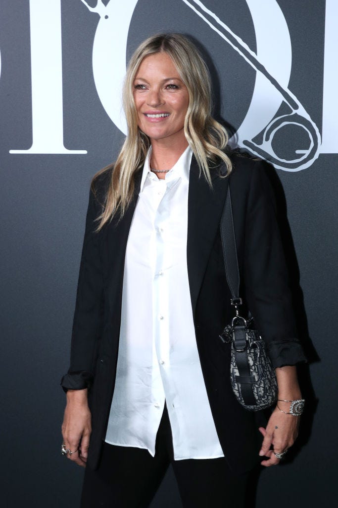 Kate Moss attends a Fashion Week event wearing a loose black blazer with white buttons