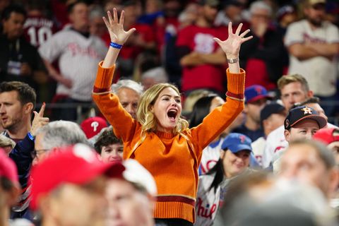 kate upton cheering with her arms in the air at world series game