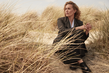 kate winslet sits on a beach