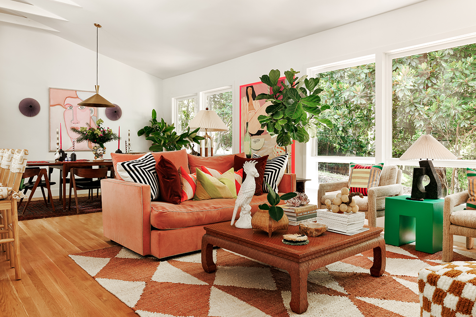 living room featuring a coral sofa decorative pillows and art pieces