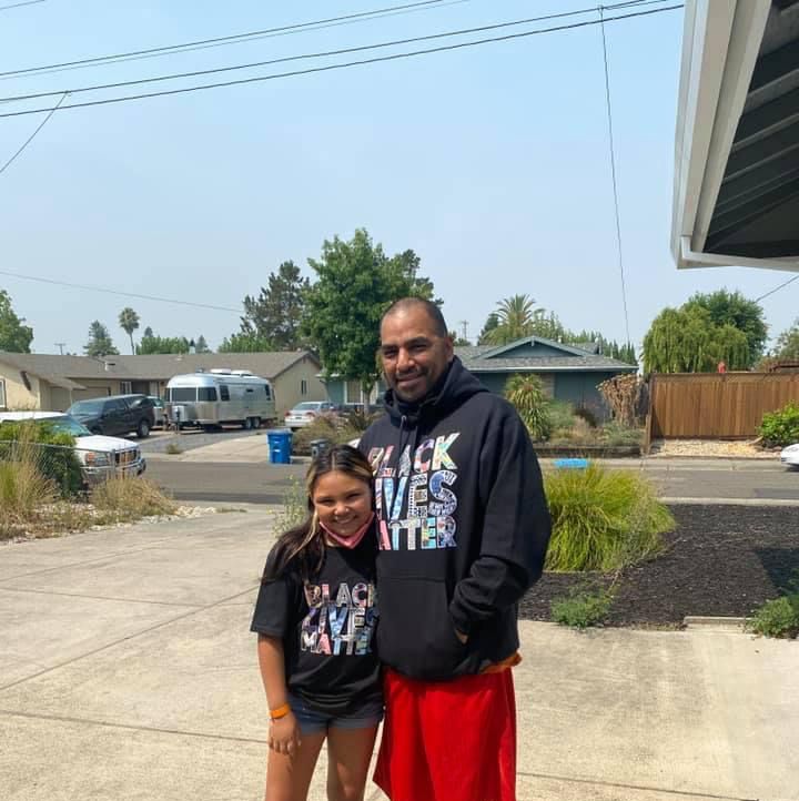 father and daughter posing wearing black lives matter t shirts
