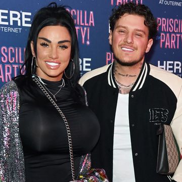 katie price and jj slater, a woman and man smile at the camera, she has long black hair and wears a black top with silver jacket, he has short curly brown hair and wears a white tshirt with sports jacket