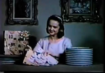 a woman pulling gift wrap out of a hat box