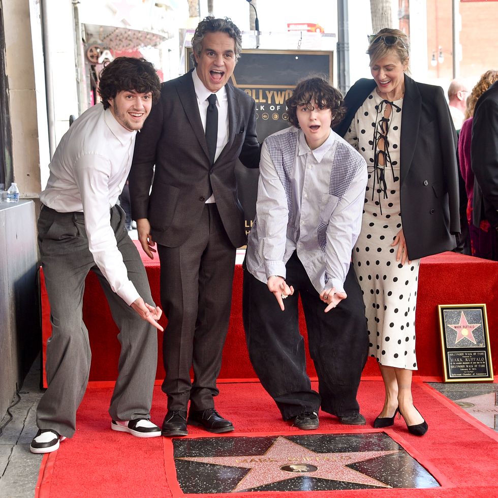 keen ruffalo, mark ruffalo, bella ruffalo, and sunrise coigney smile and pose for photos while standing on a red carpet behind a star on the ground bearing marks name