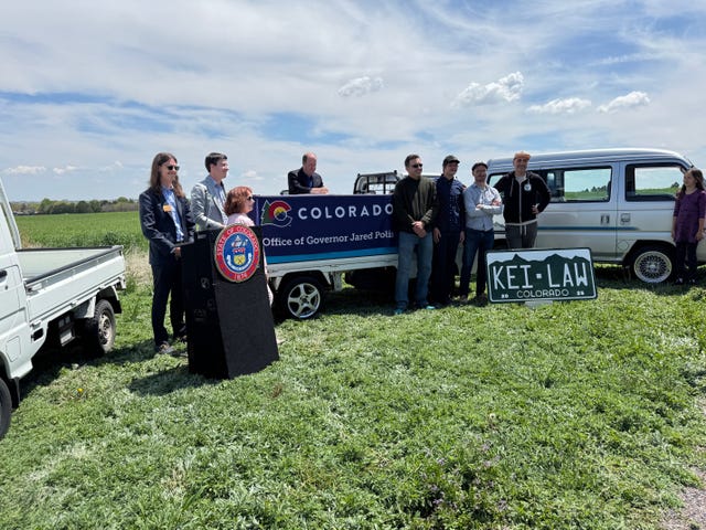 group event near vehicles and a sign reflecting a legal context