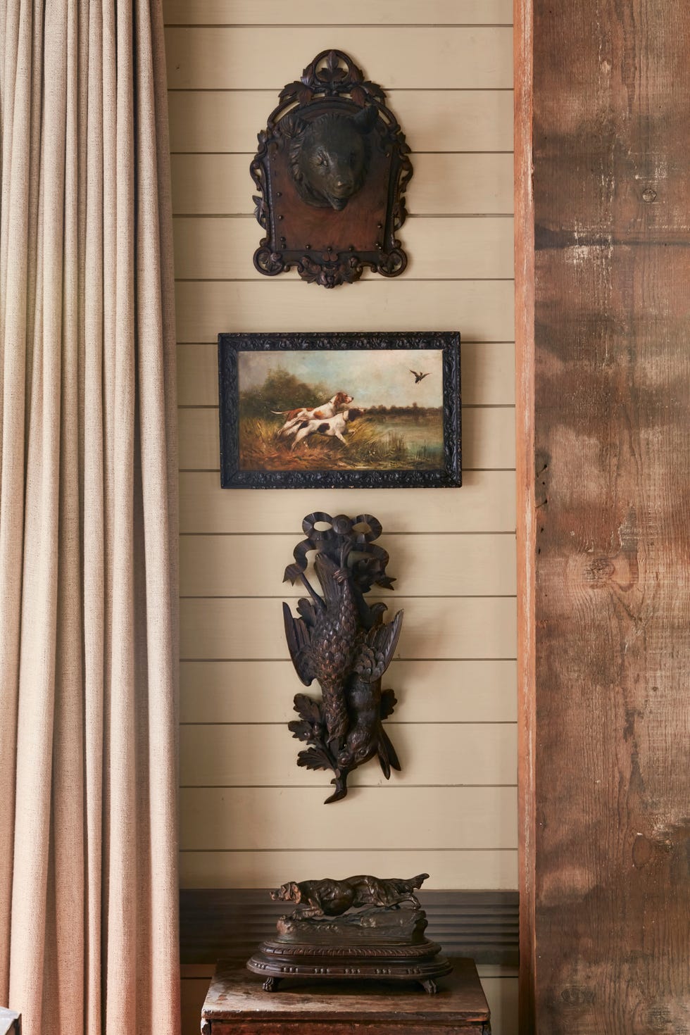 cream colored wall with pieces of hunting themed art