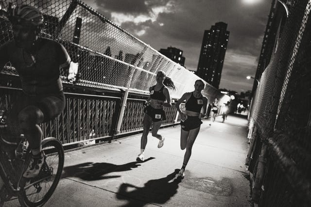 runners participating in a nighttime race on a bridge