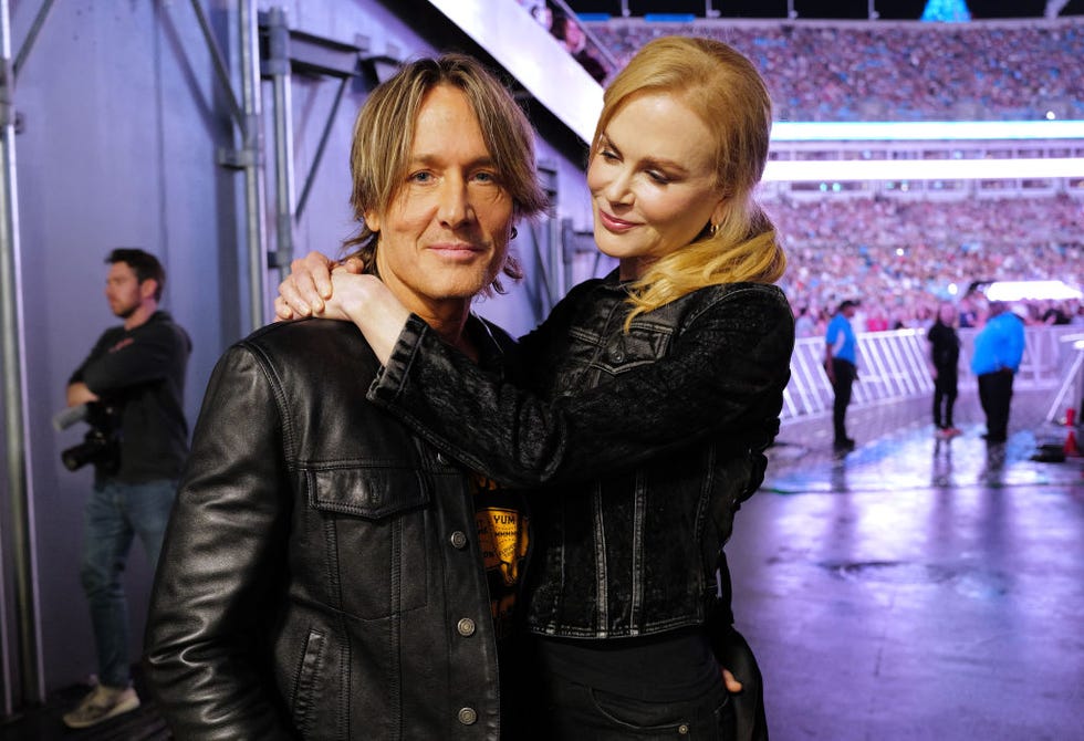 nicole kidman embracing keith urban in a stadium entranceway as a crowd looks on