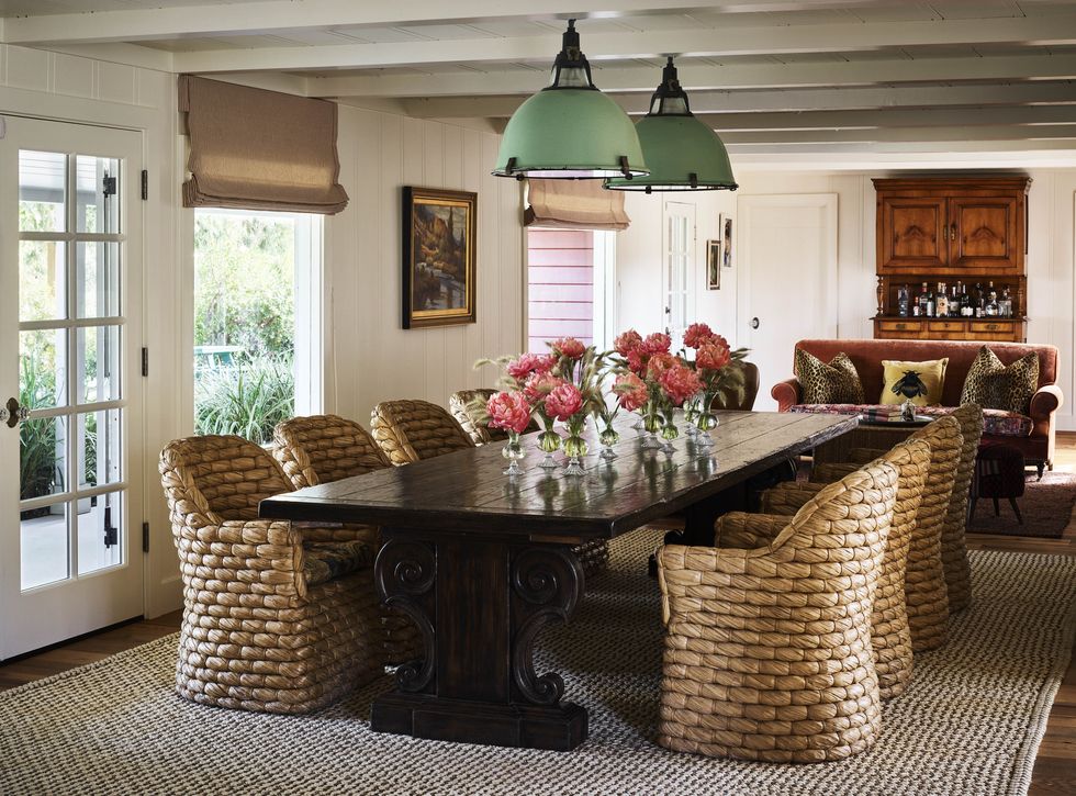 green metal industrial pendants animate the ranch house’s dining room which is furnished with a spanish trestle table