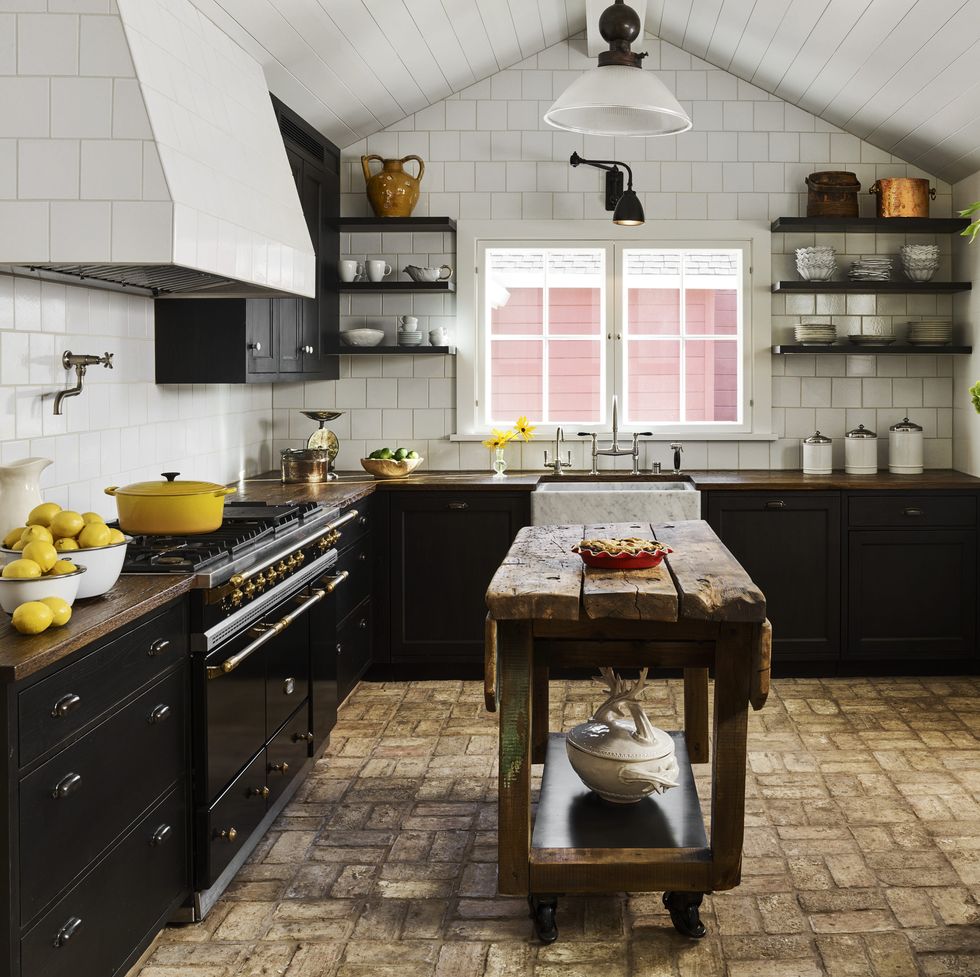 ceiling height wall tiles in alternating dimensions and reclaimed brick flooring and oak countertops anchor the kitchen in beautiful rusticity