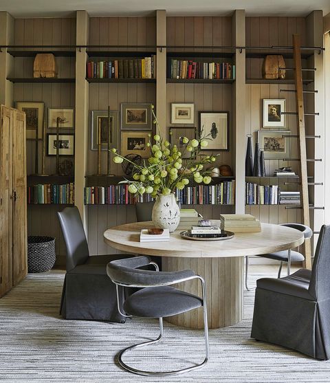 an intimate dining area doubles as a library and is anchored by an oak table crafted entirely from remnant flooring panels