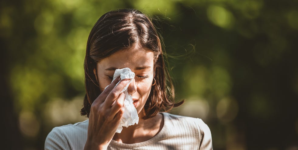 woman blowing her nose with handkerchief in public