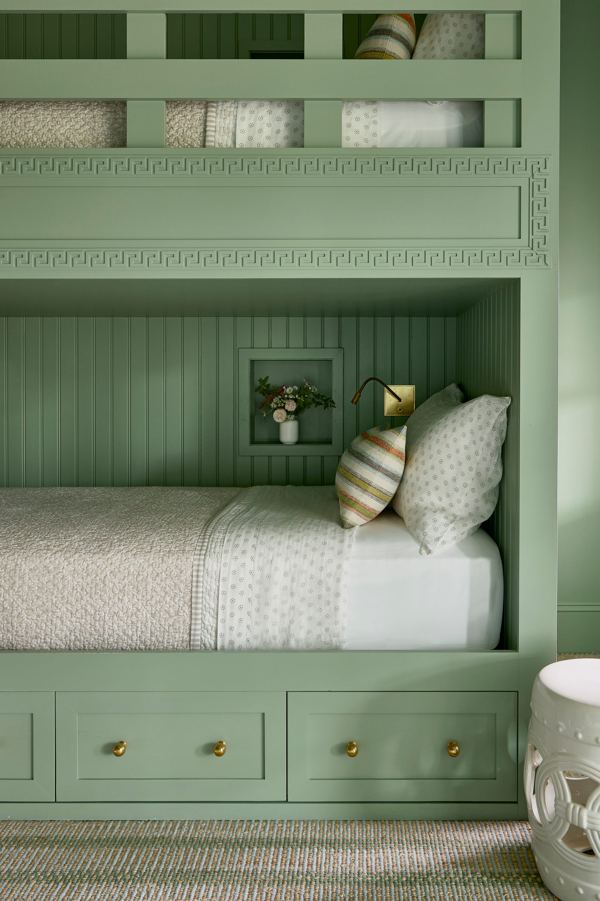 bunk bedroom with built in wood beds painted green and neutral bedding