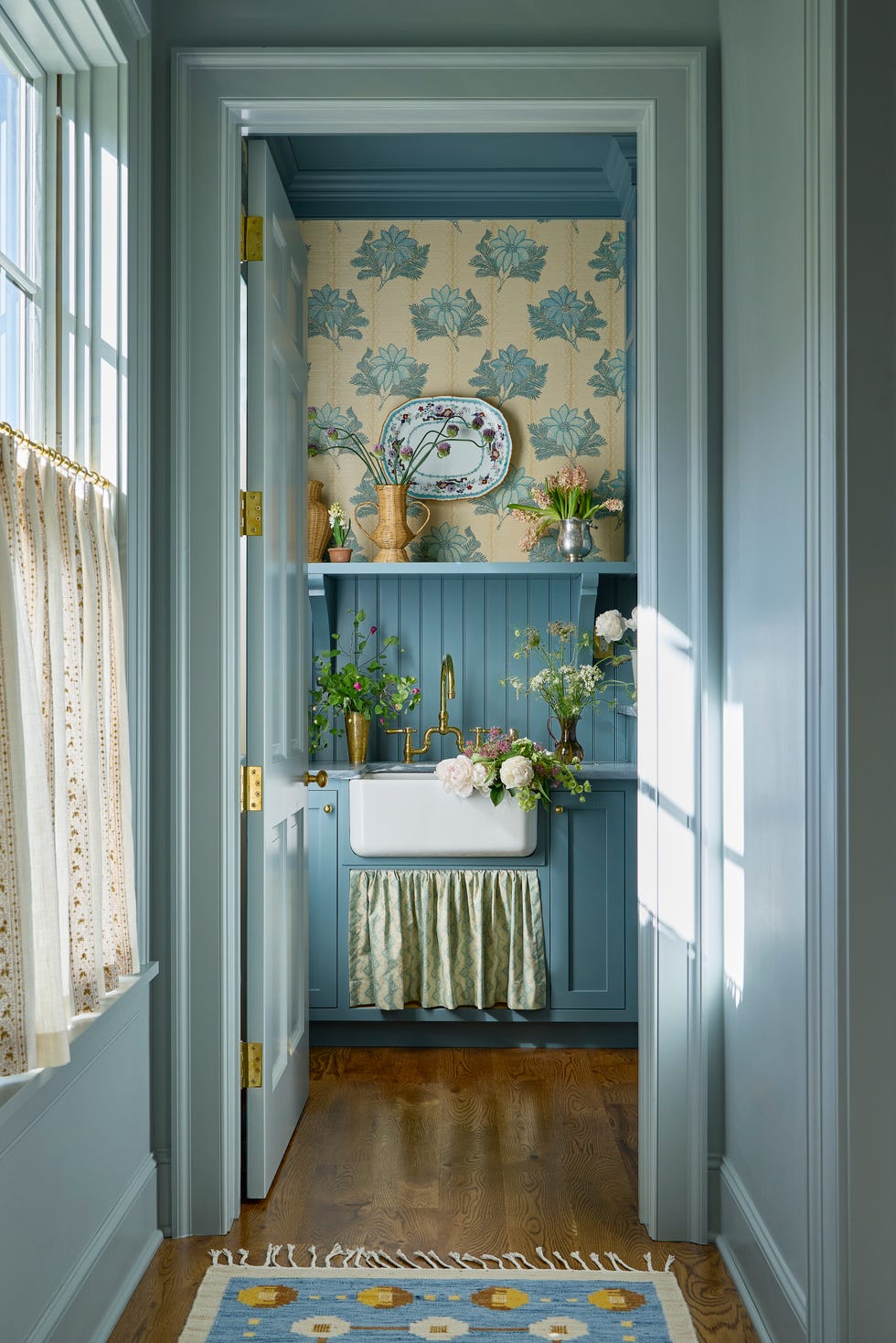 laundry room with blue walls and floral wallpaper and an apron front sink