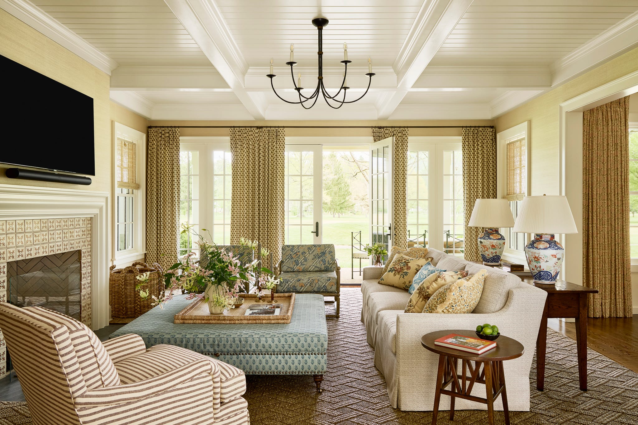 living room with couch and chairs around an ottoman with curtains on the windows