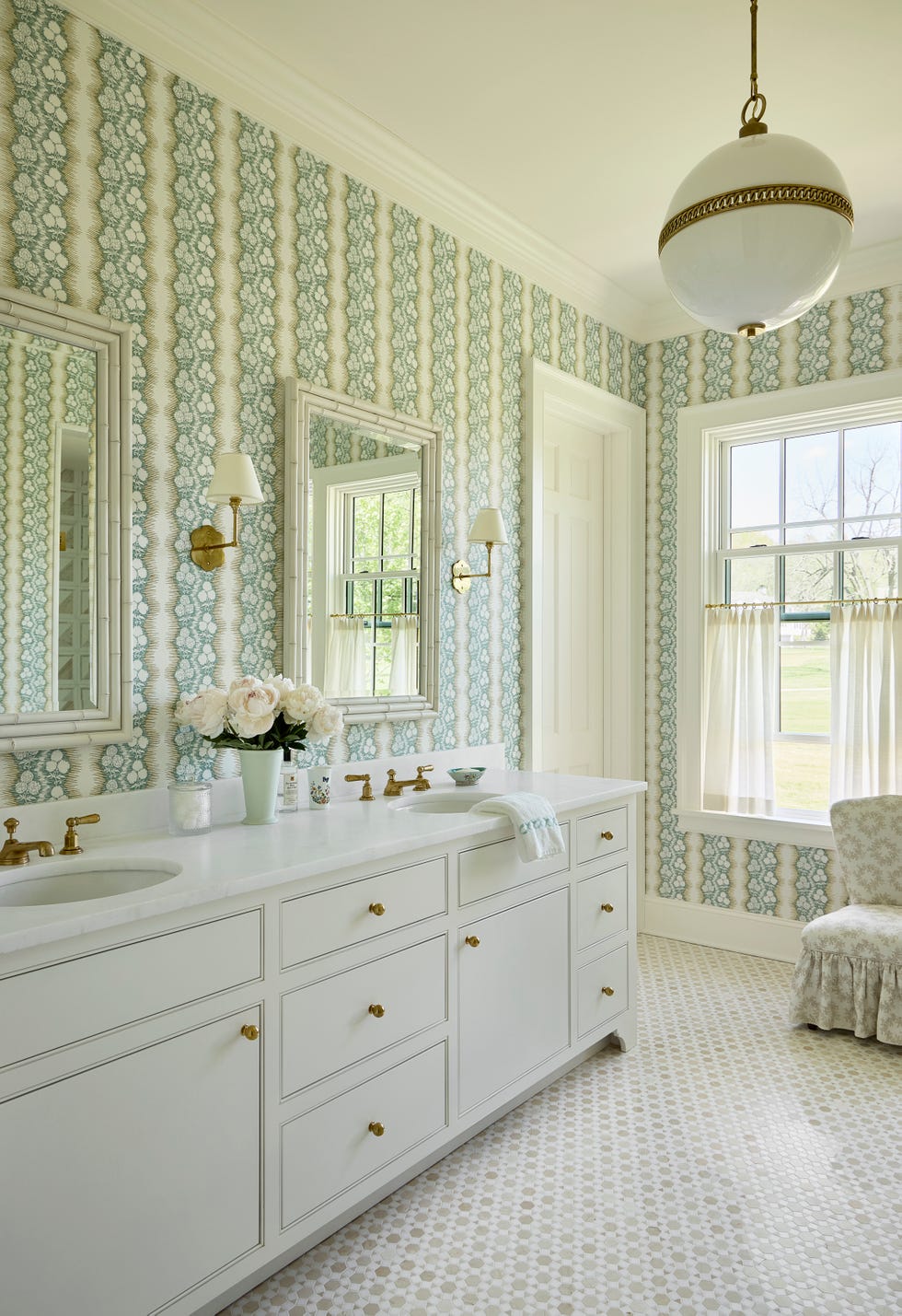 primary bathroom with white cabinetry and a patterned wallpaper