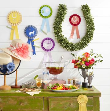kentucky derby day party kentucky benedictine dip, betting ribbons, hats on vintage stands, horseshoe “wreath”, flowers in vintage trophy “vases”