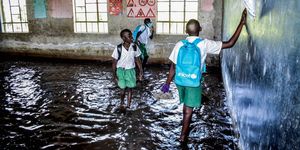 students walk in a flooded classroom caused by the overflow of lake victoria in kisumu, kenya, on january 4, 2021 during the official re opening day of public schools in kenya following a closure ordered by the government in march 2020 to curb the spread of the covid 19 coronavirus photo by brian ongoro  afp photo by brian ongoroafp via getty images