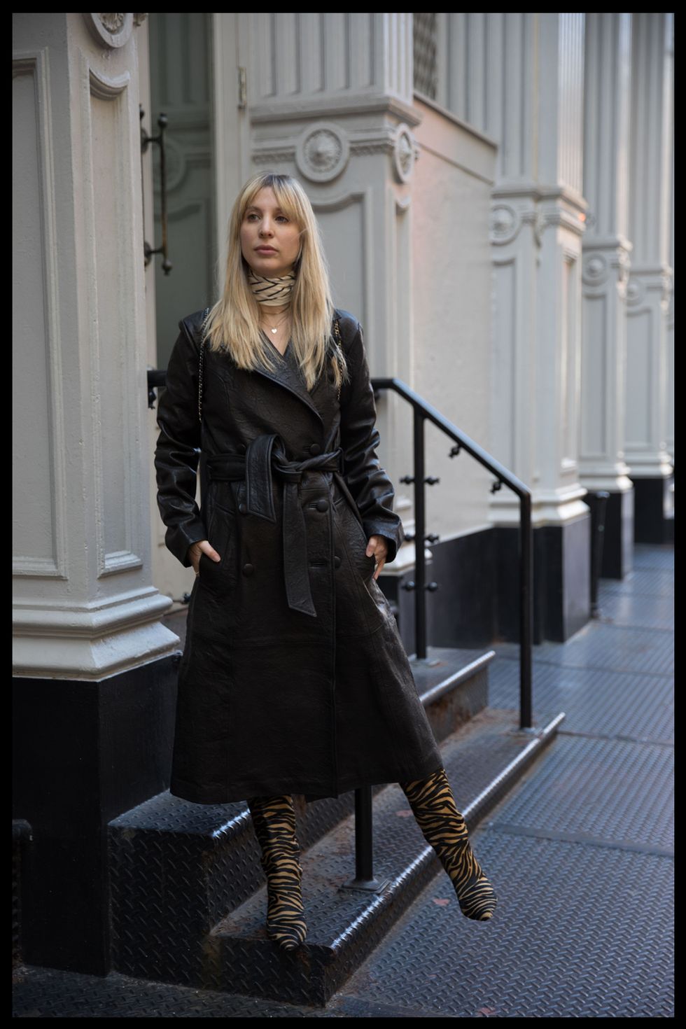 kerry pieri stands in soho wearing a black leather trench coat to illustrate her fashion resolution for 2022