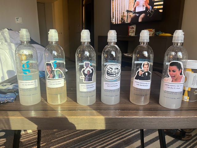 plastic water bottles labeled for various aid stations at a race event