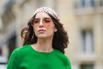 mujer con vestido verde, gafas de sol y panuelo en la cabeza