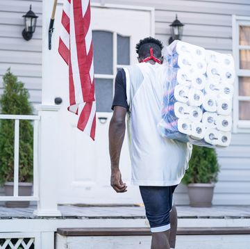 men holding a package of toilet paper in front of the porch after panic buying, during covid 19