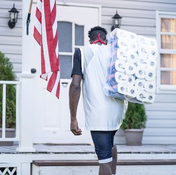 men holding a package of toilet paper in front of the porch after panic buying, during covid 19