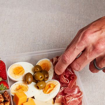a hand reaching into a container of keto snacks