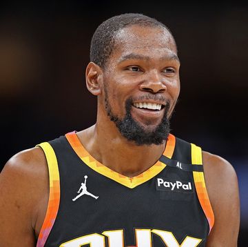 man in basketball jersey smiling and looking to right of frame