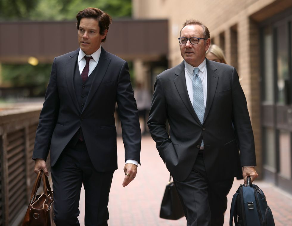 kevin spacey holding a briefcase in his left hand and walking into court