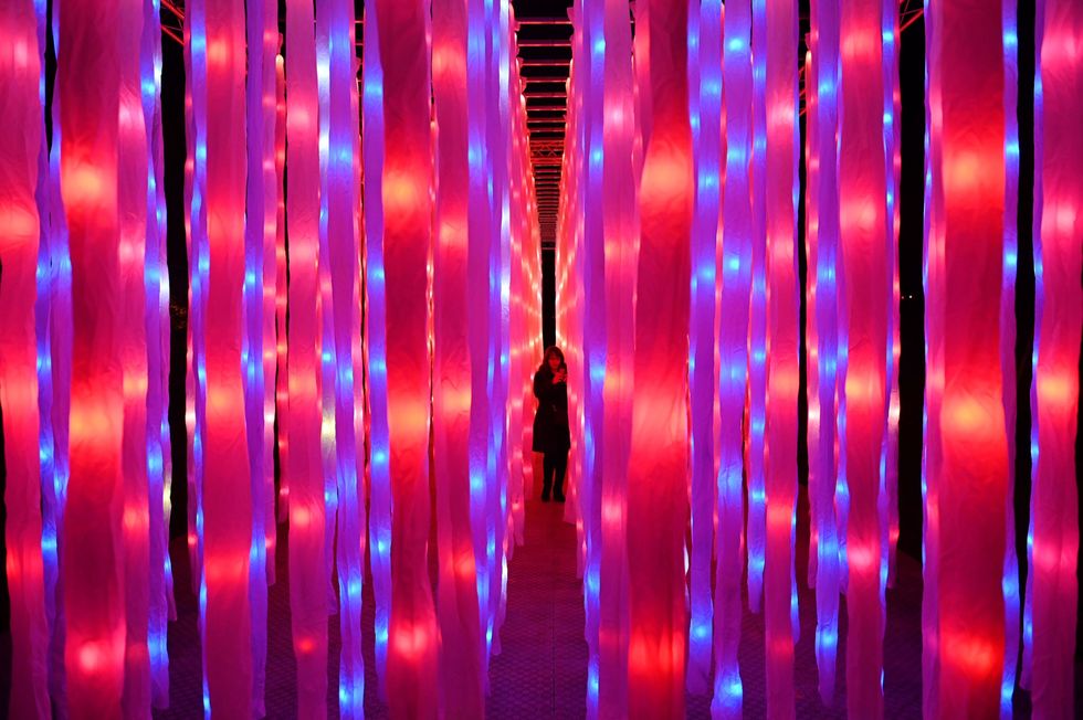 a visitor walks through a light installation entitled 'vines" during a photocall at kew gardens in south west london, on november 19, 2019, during an event to promote the launch of the "christmas at kew" event   the christmas at kew trail is illuminated with numerous light art installations especially commissioned photo by daniel leal olivas  afp photo by daniel leal olivasafp via getty images