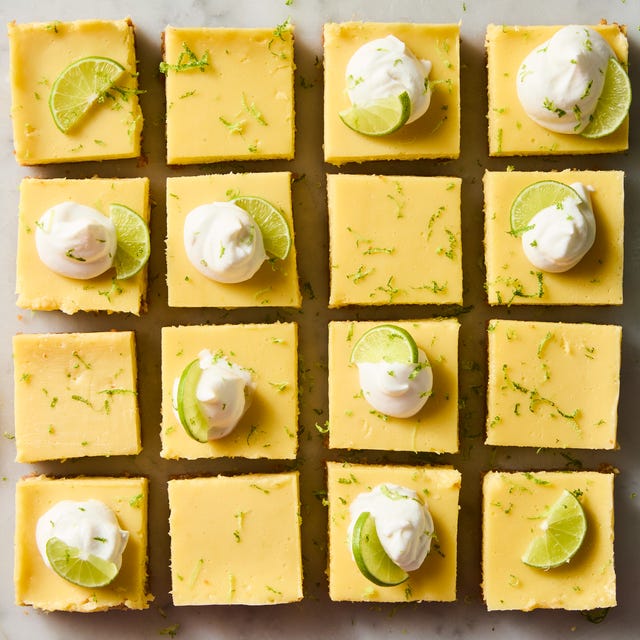 key lime bars topped with whipped cream, a lime zest, and a lime wedge