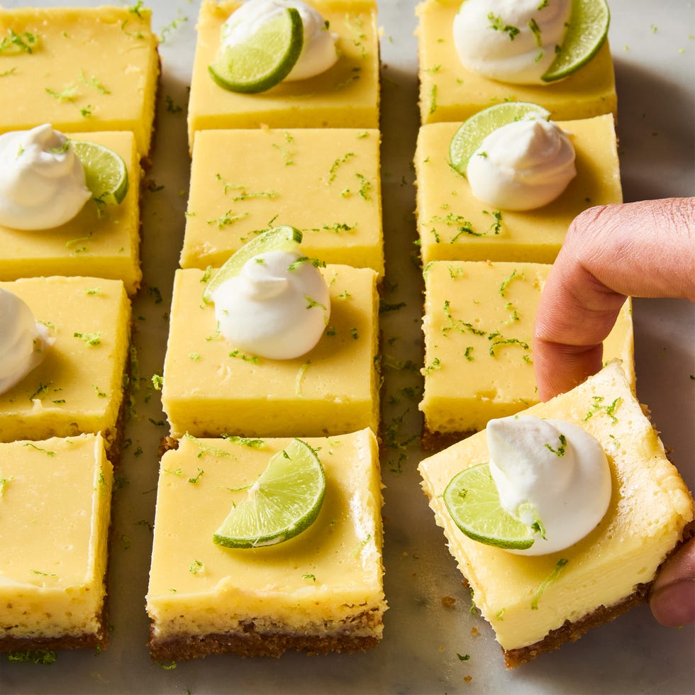 key lime bars topped with whipped cream, a lime zest, and a lime wedge