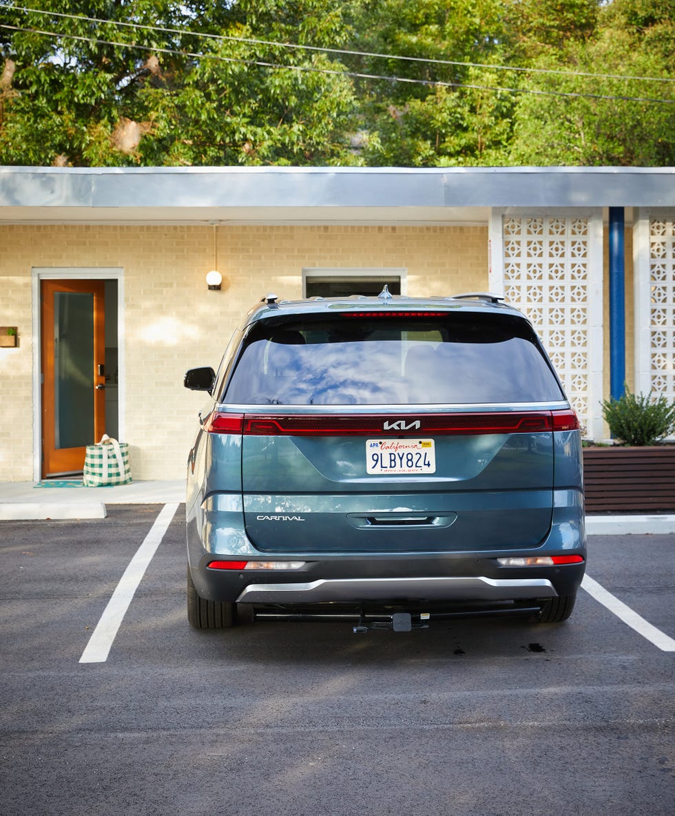 a parked kia carnival minivan facing a motel