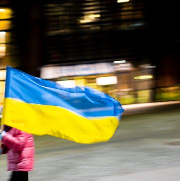 a kid runs while holding a ukrainian flag at the solidarity