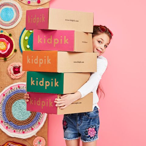 girl holding multiple kidpik clothing subscription boxes, good housekeeping pick for best subscription boxes for kids