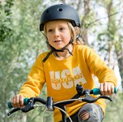 kid riding bike in woods with black helmet