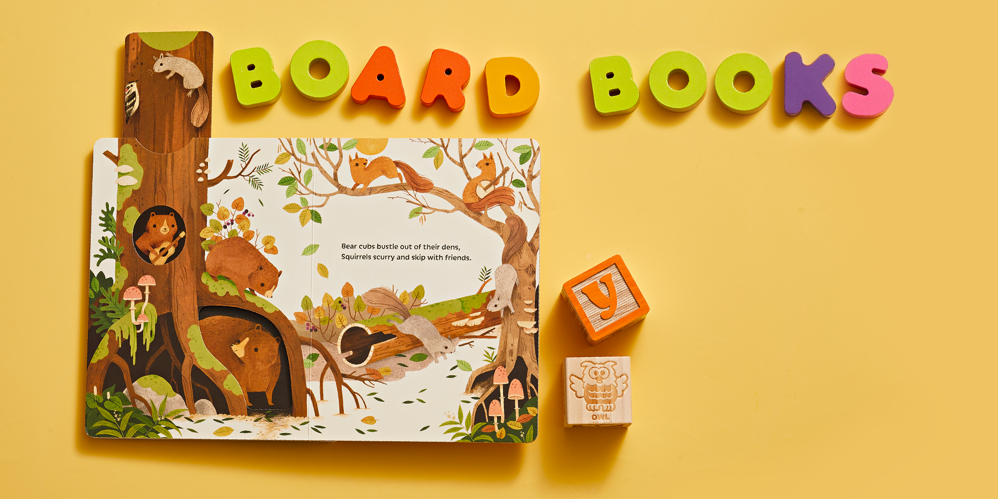 open book on yellow background with colorful blocks spelling out board books