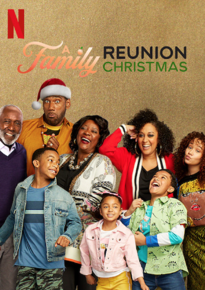 a black family with the dad wearing a santa hat and all are laughing