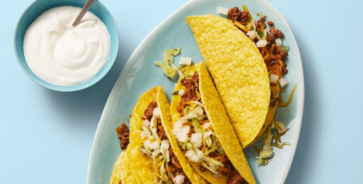 turkey tacos on a plate with a side of sour cream