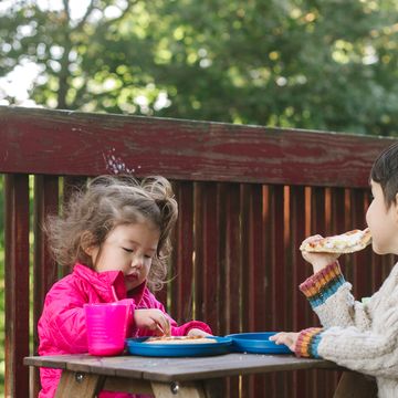 young kids eating at a kids picnic table on deck